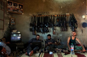 In this Tuesday, June 12, 2012 file photo, Free Syrian Army fighters sit in a house on the outskirts of Aleppo, Syria.
