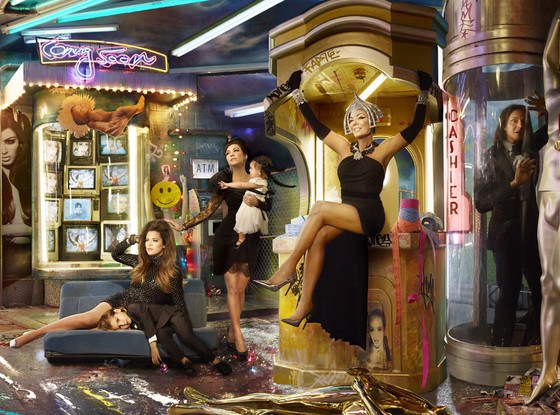 Khloe Kardashian poses sitting on the backseat of a car (why?) while Kourtney’s son Mason lays on it, looking as if life was sucked out of him. Above them is a cardboard cutout looking like a baby-Jesus, with a glory around its head. Is that North West? The matriarch of the family, Kris Jenner looks like some kind of female Pharaoh while Bruce is distress, stuck in a tube, about to run out of air. Between them is the word “cashier”, maybe meaning that it is all about money transactions. Above both of them is tagged the word “fame”, implying that they’re ready to do whatever it takes to be famous.