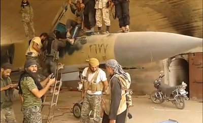 Screen shot of fighters purportedly belonging to Al Nusrah on top of an abandoned MIG at the airbase