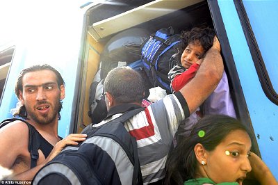 Migrant Afghan and Syrians cram onto train to Croatian capitol on Saturday Oct 19.