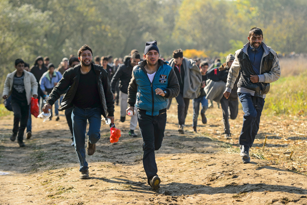 Migrants and refugees run to a refugee center after crossing the Croatian-Slovenian border near Rigonce on October 24, 2015. Slovenia says it is considering building a border fence to help stem a record influx of migrants and refugees, as thousands more people arrived from Croatia on October 23. AFP PHOTO / JURE MAKOVEC (Photo credit should read Jure Makovec/AFP/Getty Images)