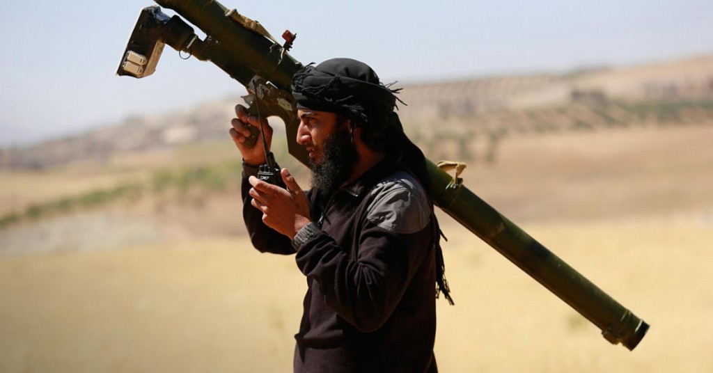 An Islamist Syrian rebel group Jabhat al-Nusra fighter talks on a walkie-talkie while carrying his weapon on Al-Khazan frontline of Khan Sheikhoun, northern Idlib province May 17, 2014. REUTERS/Hamid Khatib (SYRIA - Tags: CIVIL UNREST MILITARY POLITICS CONFLICT) - RTR3PMA6