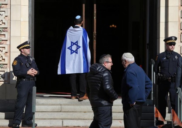Police stand at the entrance to Rodef Shalom Temple before funeral services for brothers Cecil and David Rosenthal, victims of the Tree of Life Synagogue shooting, in Pittsburgh. Click to enlarge
