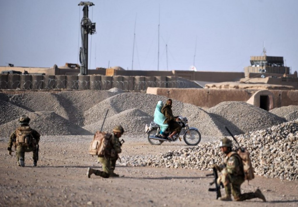 An Afghan couple ride past soldiers from the 1st Battalion The Rifles on patrol in Nahr-e Saraj in Helmand in June 2010. Click to enlarge