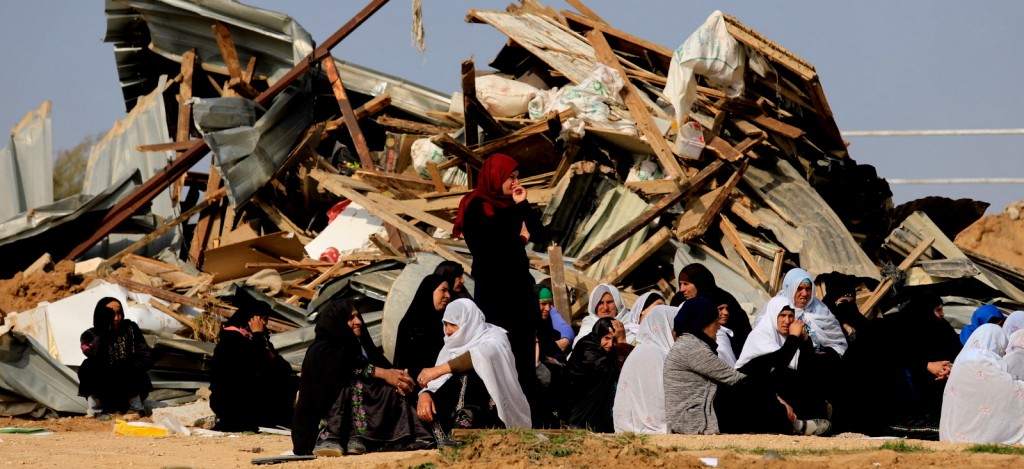 Bedouin women sit outside a demolished home by Israeli forces in the southern village of Umm al-Hiran, Jan. 18, 2017. Tsafrir Abayov | AP