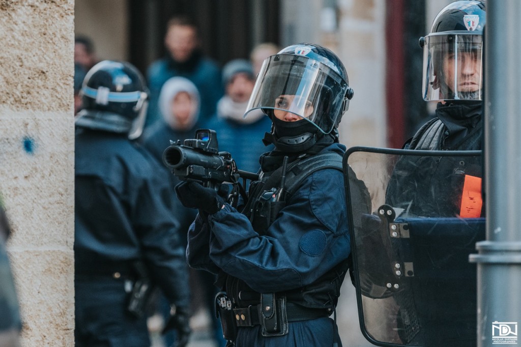 A police officer takes aim with the LBD40 “flashball” bullet launcher. Photo: Nicolas Duffaure, Bordeaux. Click to enlarge