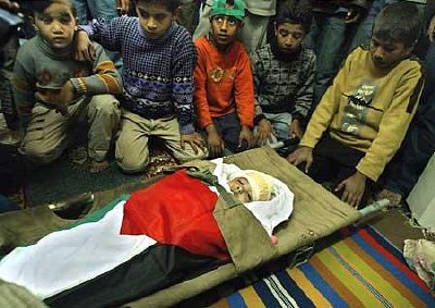 Palestinian boys gather around the body of Rahma Abu Shamas, the 3-year-old hit in the head by Israeli gunfire while she was inside her home. Photo: MAHMUD HAMS
