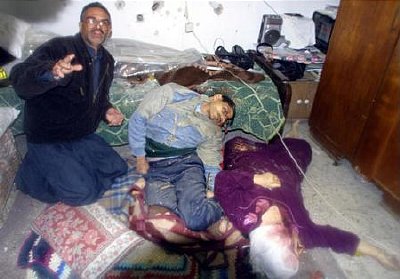 Sami Abden and the bodies of his mother and brother, who were shot during a fire fight between Israelis and Palestinians. Both of who then bled to death after ambulances were stopped by Israeli troops.