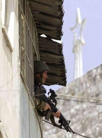 An Israeli sniper with the spire of the Church of the Nativity in the background.