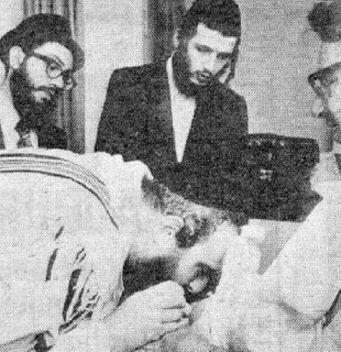 The photo above is not a pornographic image of a Rabbi giving oral pleasure to a newly born Jewish baby. It is actually Mohel Rabbi Yosef David Weisburg sucking blood from a baby’s penis while performing a circumcision