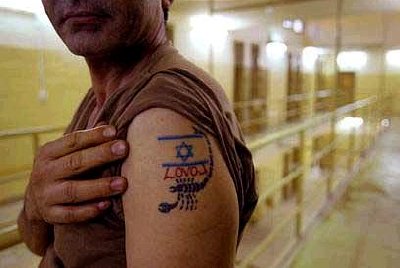 Tatoo worn by guard at Abu Ghraib prison, Iraq.